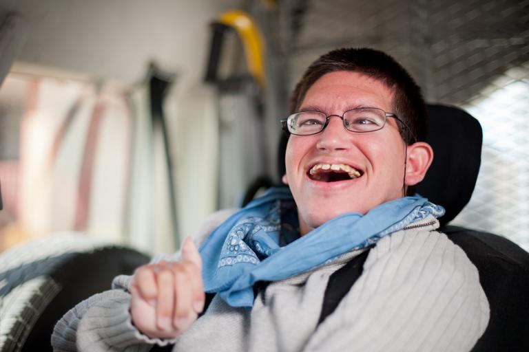 Man with physical disability sat in his vehicle. Smiling